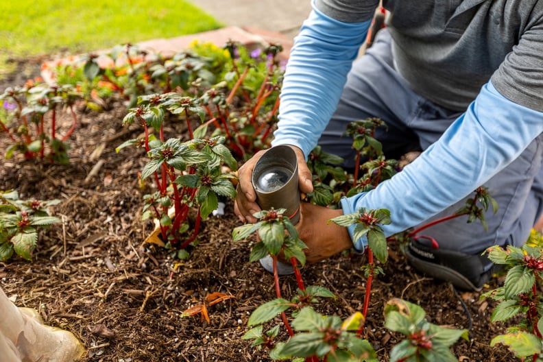 landscape lighting technician repairing light