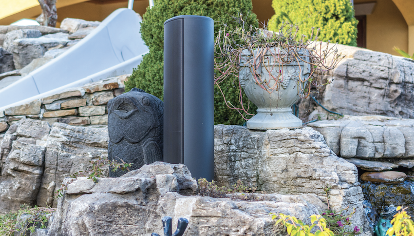 Outdoor audio tower speaker in landscape near outdoor pool